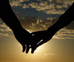 Holding hands with sunset background